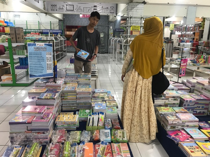 PERMINTAAN NAIK: Seorang pelajar bersama orang tuanya memilih buku tulis di Toko Buku Togamas kemarin siang.