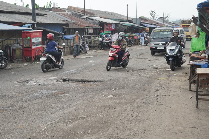 DIBUAT JALAN KEMBAR: Pemotor menghindari lubang di Jalan Pasar Gadang kemarin.