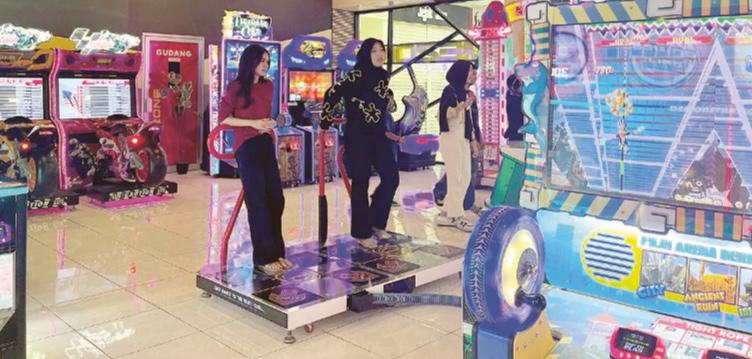 Dua pengunjung mal menikmati wahana permainan kemarin. Mal kini mulai bertransformasi menjadi tempat rekreasi alternatif.