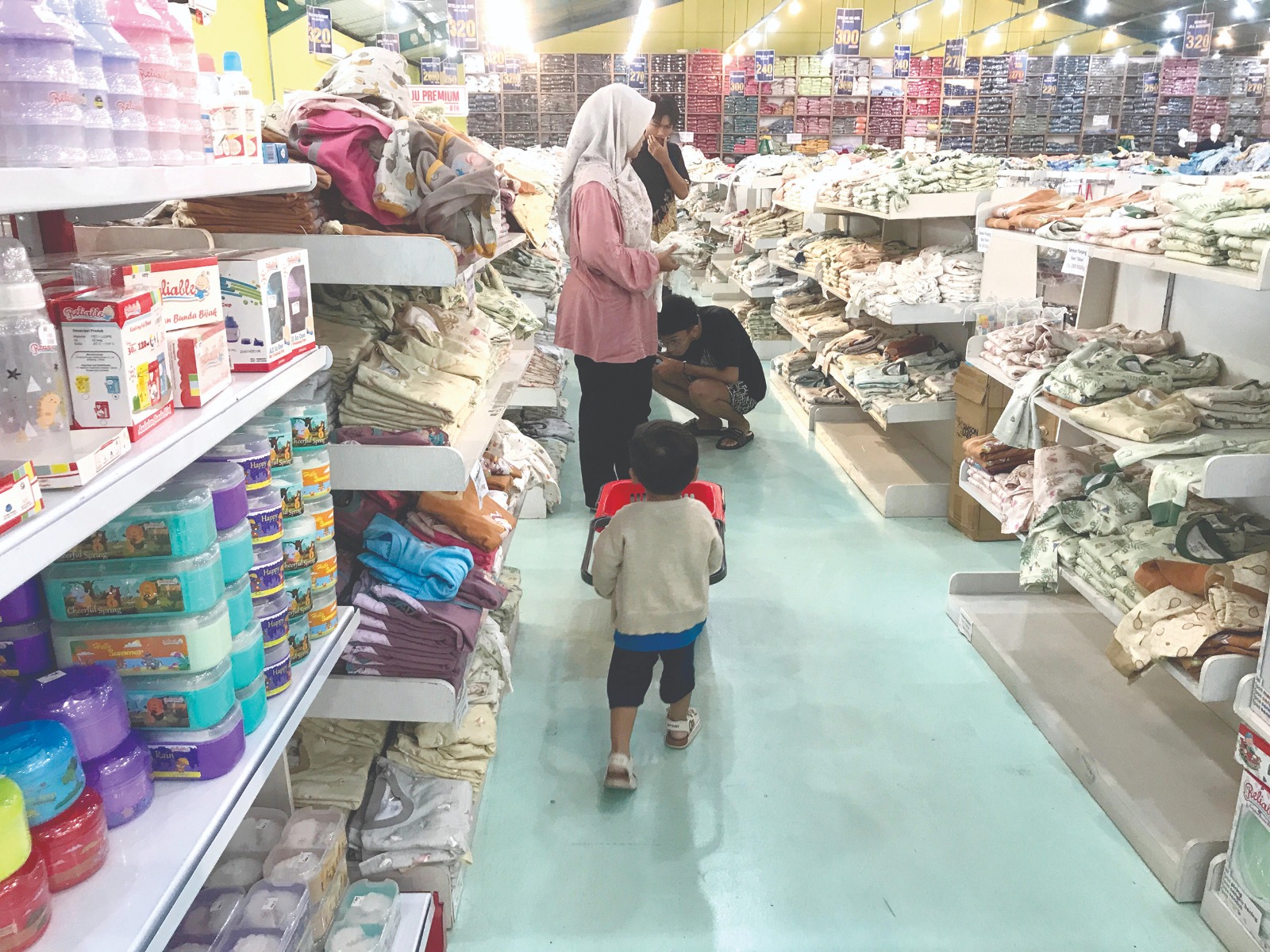 KEBUTUHAN PRIMER: Pengunjung memilih pakaian bayi yang tersusun di rak kemarin.