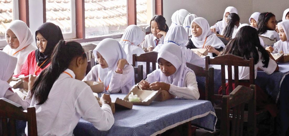 PASTIKAN BERGIZI: Para pelajar SRMP 14 Kota Batu menyantap makan siang bersama di ruang makan, kemarin (15/7).