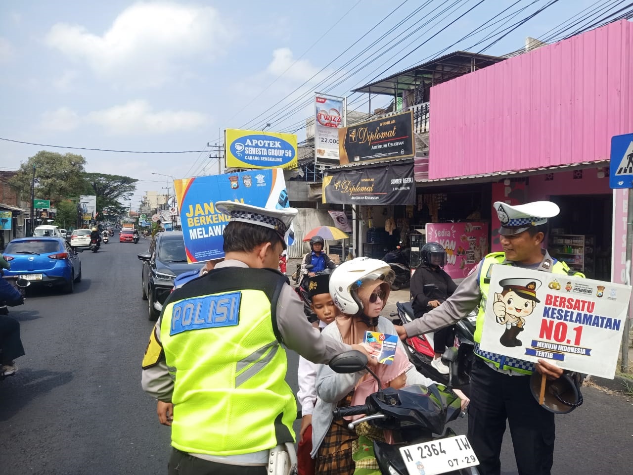 TEGURAN: Dua personel Satlantas Polres Malang memberhentikan pengendara yang melanggar tata tertib berlalu lintas di Kecamatan Dau kemarin (16/7).