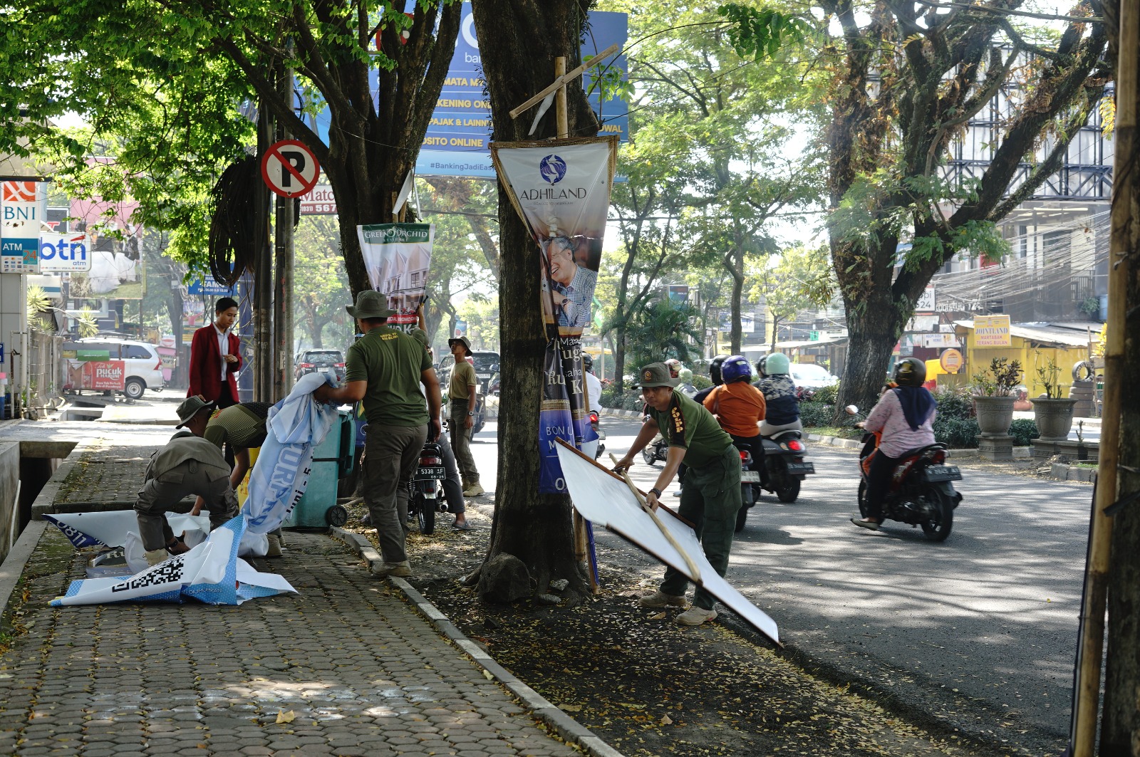 LANGGAR KETENTUAN: Banner insidentil yang terpasang di pohon-pohon di Jalan Soekarno-Hatta ditertibkan personel Satpol PP, kemarin. Patroli rutin digelar mereka setiap hari.