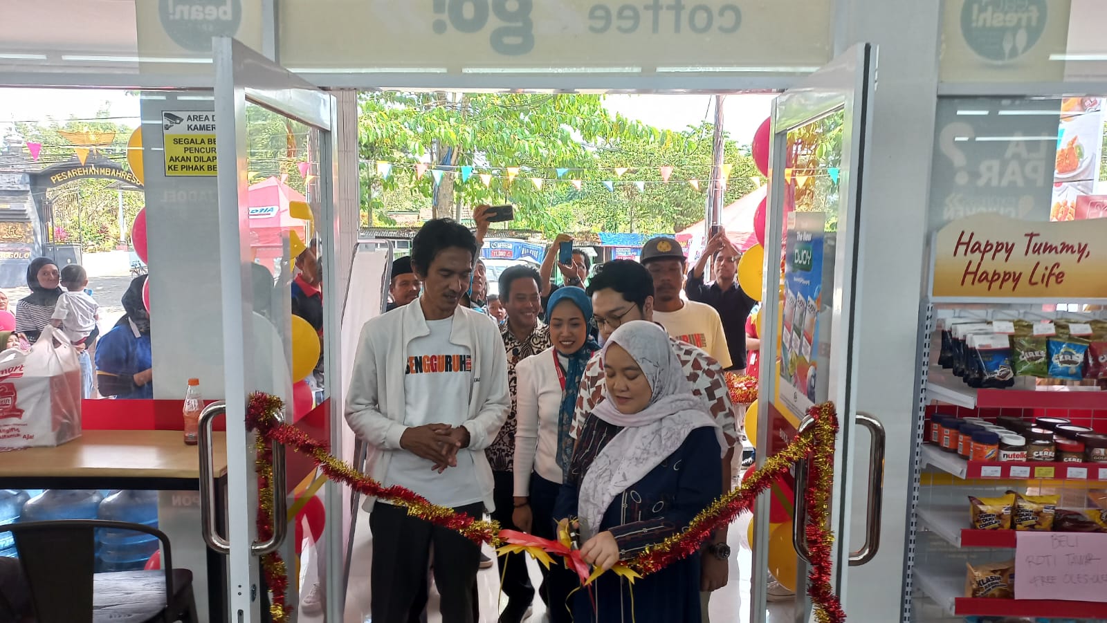 POTONG PITA: owner Alfamart Sengguruh (kanan) memotong pita sebagai tanda dibukanya gerai Alfamart Sengguruh, Kepanjen, Kabupaten Malang, Jumat (18/7)