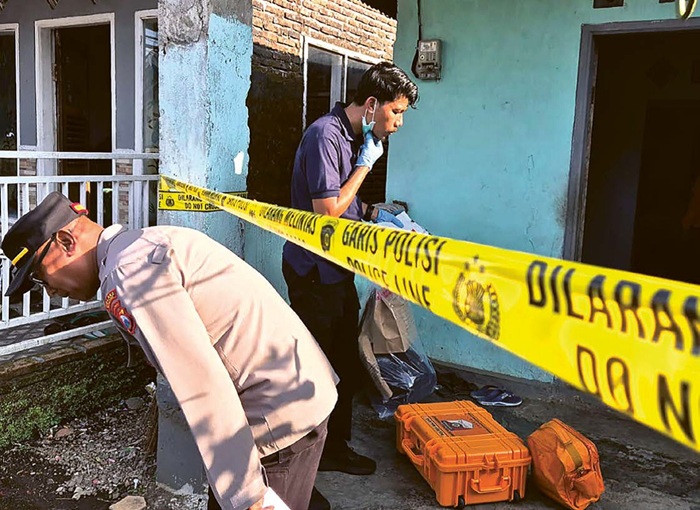 CARI BUKTI: Polisi melakukan olah tempat kejadian perkara kasus pasutri meninggal di Dusun Tegalrejo, Desa Ketindan, Kecamatan Lawang, Kabupaten Malang, kemarin pagi (22/7).