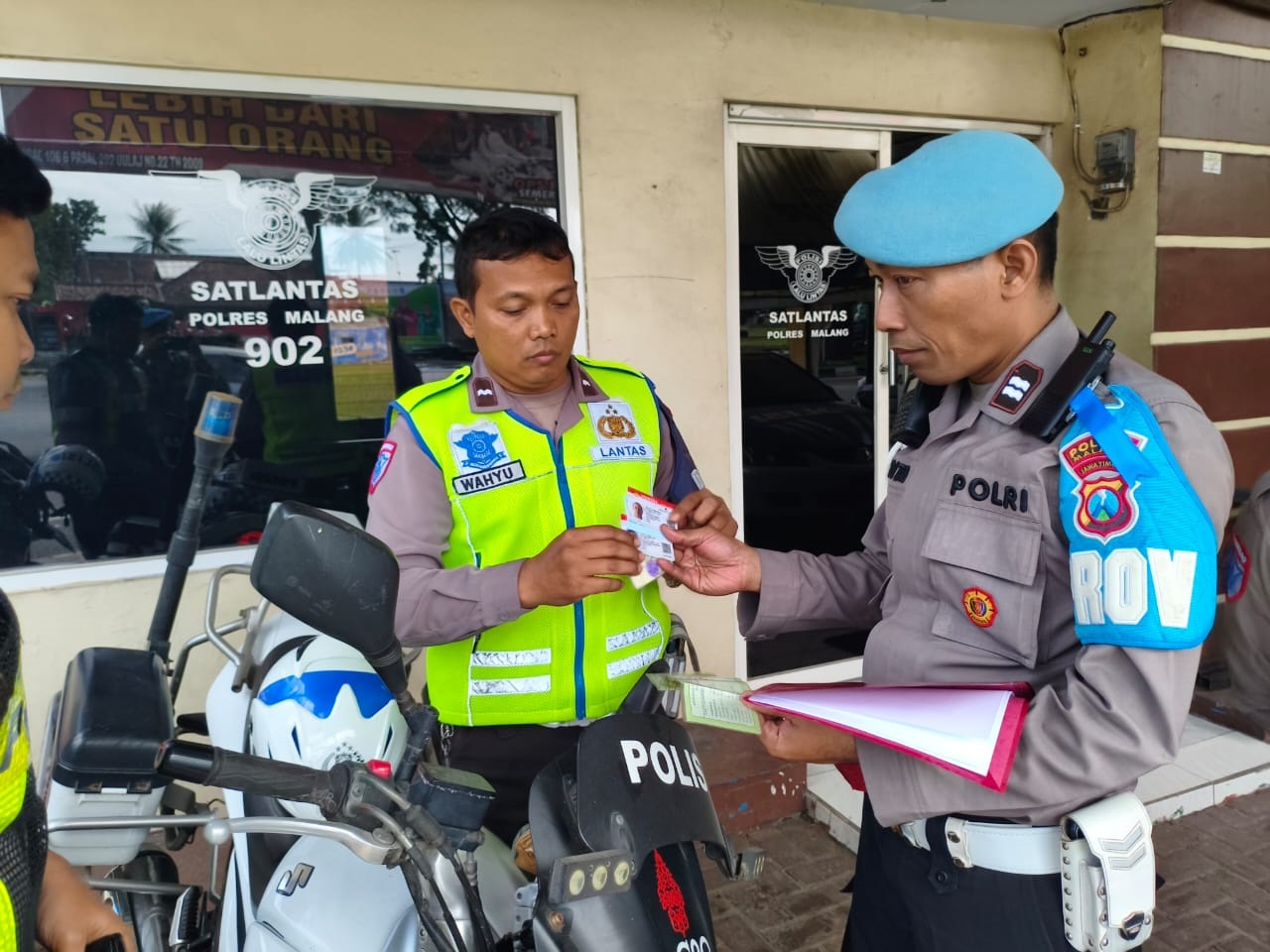RAZIA INTERNAL: Anggota Satlantas dan Propam Polres Malang memeriksa kelengkapan surat kendaraan rekannya di Mapolres Malang kemarin (22/7).