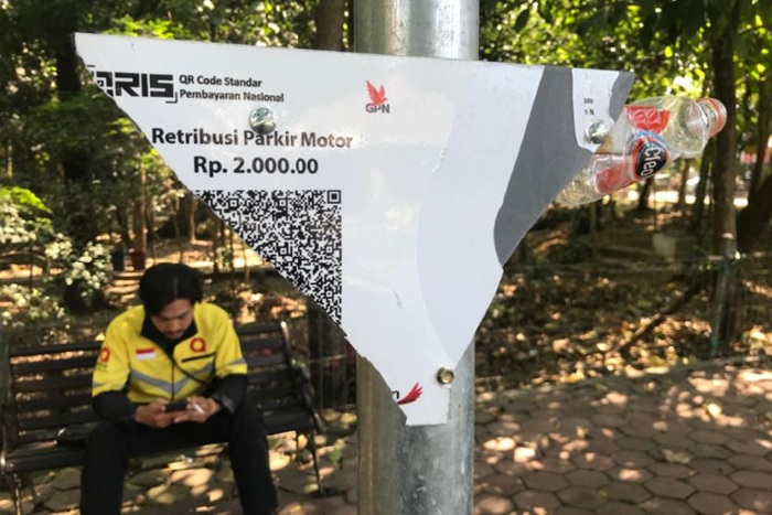 DIEVALUASI: Papan QRIS di area parkir Pasar Oro-Oro Dowo rusak sejak beberapa pekan lalu.