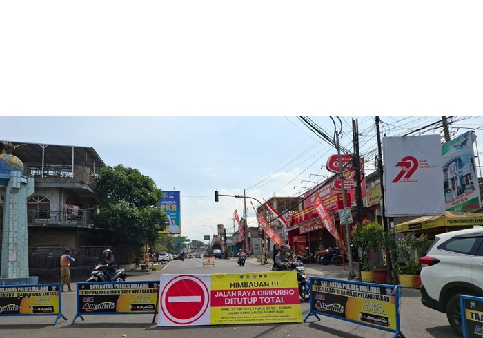 REKAYASA LALIN: Polisi memasang pembatas jalan di simpang tiga Karangploso kemarin (23/7). Pembatas tersebut berisi tulisan &rdquo;Jalan Raya Giripurno Ditutup Total&rdquo;.