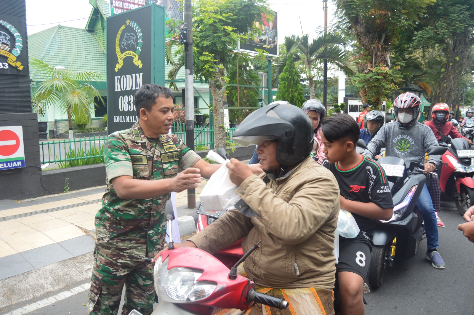 MAKIN ERAT: Anggota Kodim saat membagikan nasi kotak ke pengendara.
