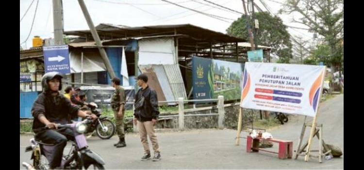 BLOKADE: Warga berjaga di simpang tiga Jalan Sasando, Karangploso kemarin (25/7). Mereka mengarahkan pengendara yang melintas.