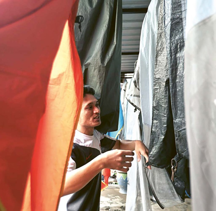 BANJIR PESANAN: Seorang pemilik jasa persewaan di Bululawang sedang menjemur tenda yang baru disewa pelanggan.