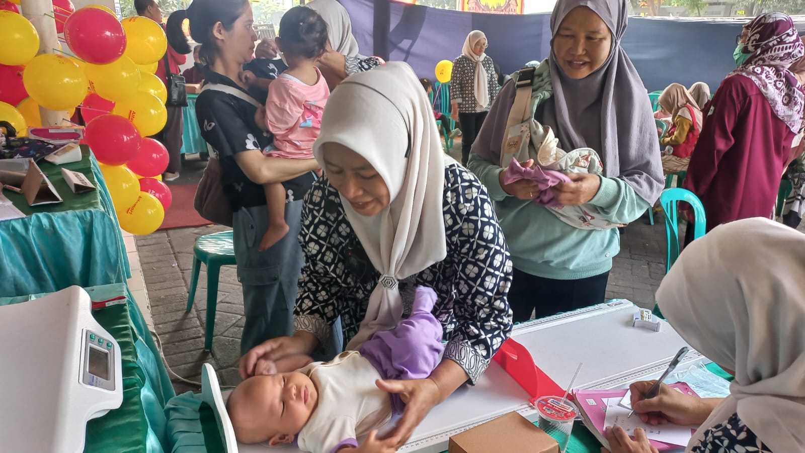 UKUR TINGGI BADAN: Petugas Posyandu sedang melakukan pengukuran tinggi badan seorang balita.