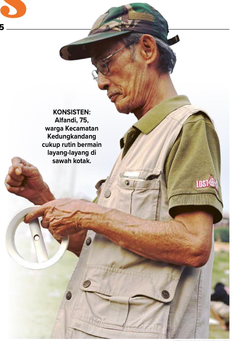 KONSISTEN: Alfandi, 75, warga Kecamatan Kedungkandang cukup rutin bermain layang-layang di sawah kotak.