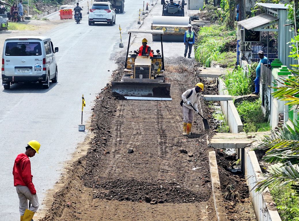 PELEBARAN: Pekerja melakukan pengerasan jalan di Desa Suwaru, Kecamatan Pagelaran, Kabupaten Malang. Ruas jalan tersebut dilebarkan dari  8 meter menjadi 11 meter.