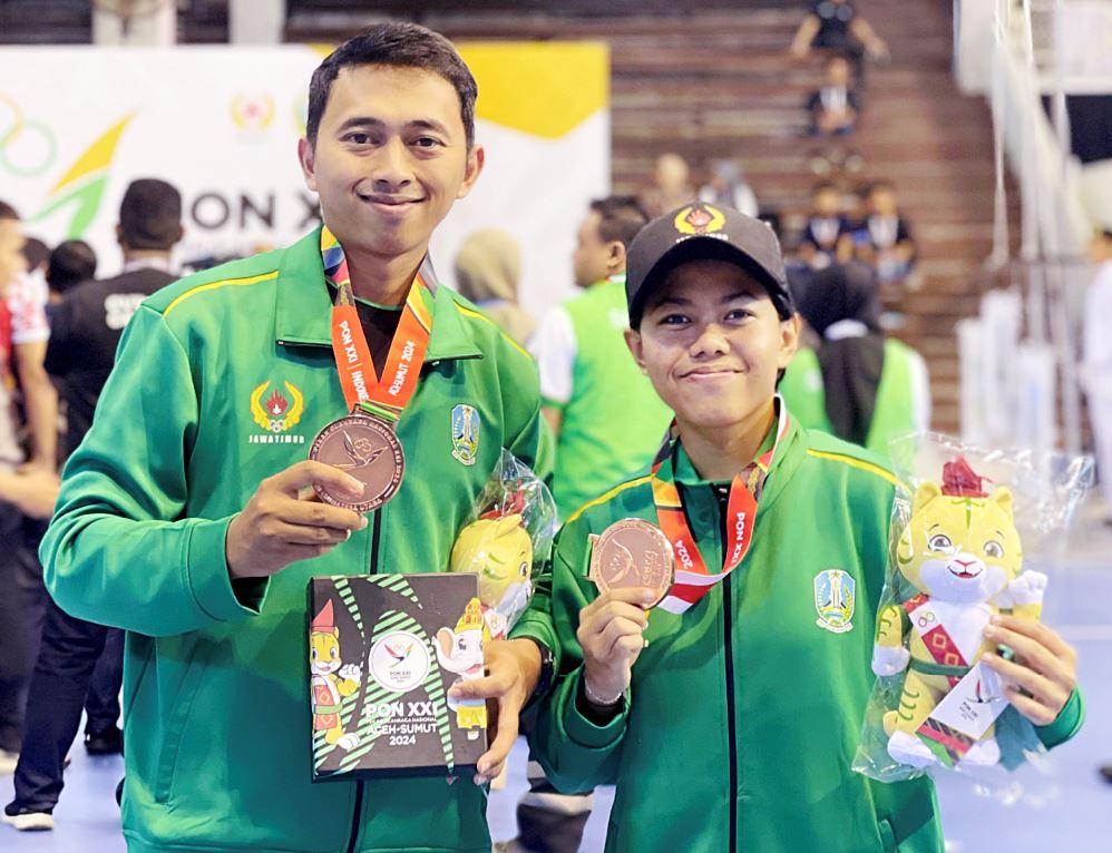TANGAN DINGIN: Rizky Revaldo (kiri) bersama Lutfi Nur Amalia (kanan) atlet putri hockey indoor Jawa Timur yang meraih medali perunggu pada ajang PON Aceh 2024 lalu.