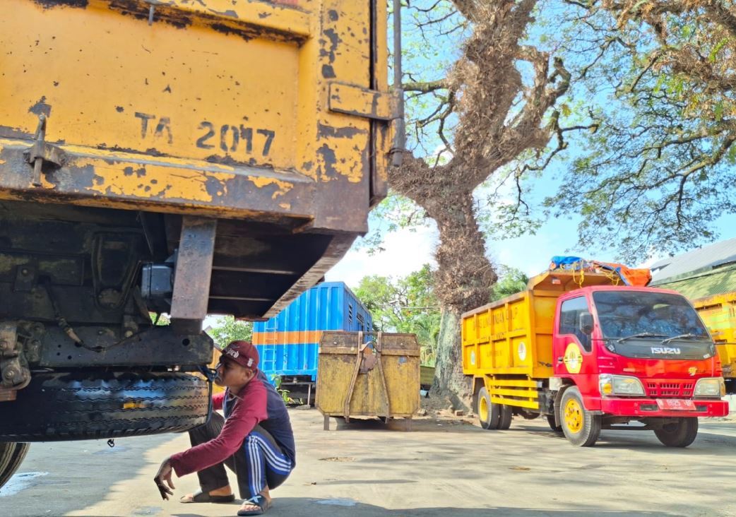 BUTUH TAMBAHAN: Salah seorang pegawai melakukan pengecekan dump truck setelah dipakai untuk mengangkut sampah di Kantor Dinas Lingkungan Hidup (DLH) Kota Malang, Senin lalu (28/7).