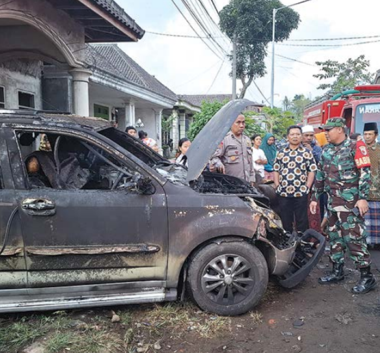 KEBAKARAN: Polisi, TNI, dan warga sekitar mengamati mobil Kosim yang hangus terbakar. Hingga tadi malam Kosim masih menjalani perawatan.