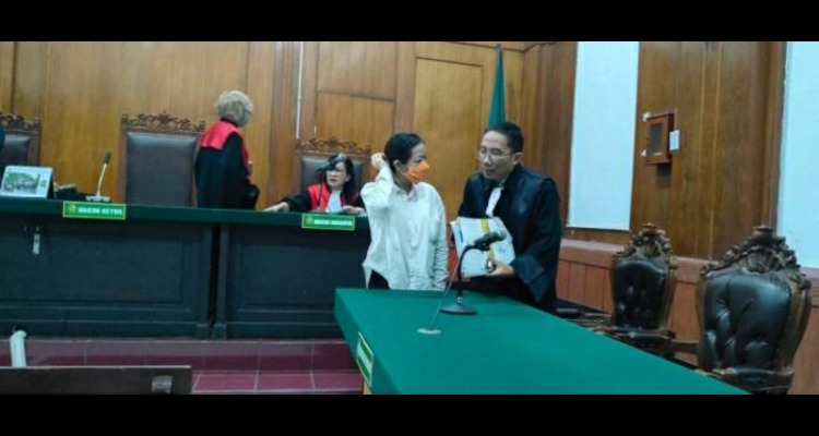 DISKUSI: Isabella Angellia Yohanes (kiri) bersama pengacaranya, Dino Wijaya di Pengadilan Negeri Surabaya, Kamis (31/7). Dia didakwa memalsukan tanda tangan mendiang bos demi mencairkan uang.