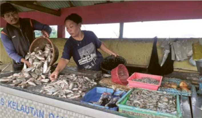 TAMBAH GIZI: Seorang pedagang di Kios Ikan Nelayan (KIN) melayani pembeli. Permintaan bertambah seiring gerakan program mengonsumsi ikan.