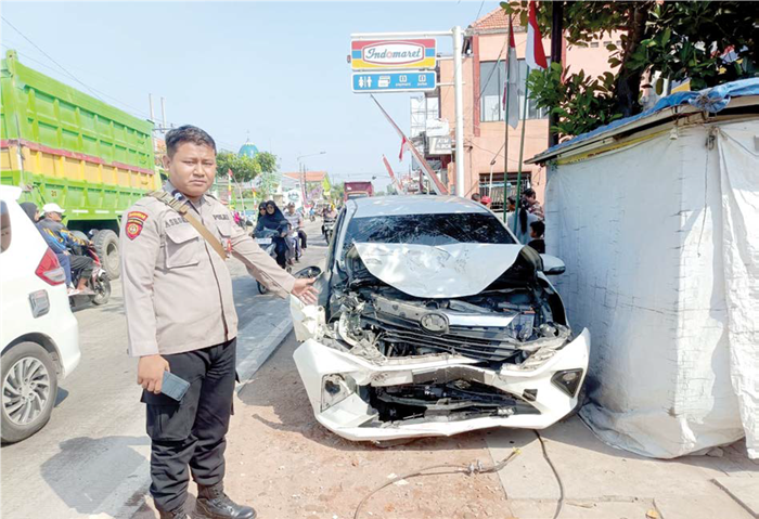 KORBAN PATAH KAKI: Petugas menunjukkan mobil yang dikendarai Irfan Mauludhin seusai kecelakaan di Jalan Raya Rejeni, Krembung, kemarin (3/8).
