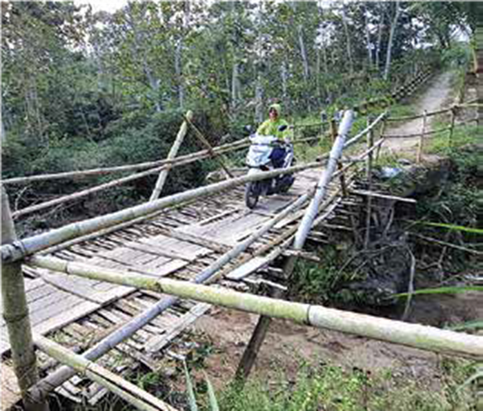 WARGA WASWAS: Seorang warga melintasi Jembatan Darurat Mentaraman dengan berhati-hati kemarin.