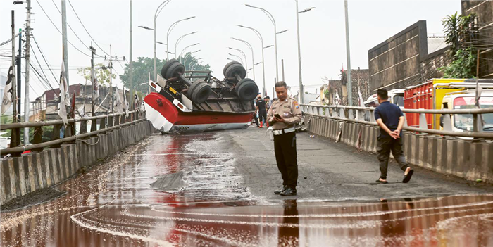 SUMBU RODA PUTUS: Salah satu tangki dari truk bernopol N 8333 UFF terguling di Flyover Kotalama, kemarin (4/8). Empat warga yang mengendarai motor dilaporkan terluka.