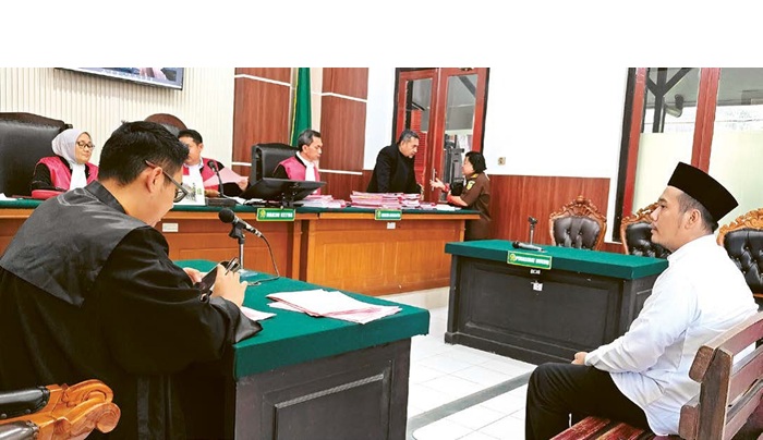 MODUS BARU: Terdakwa Alan mendengarkan jaksa penuntut umum membacakan surat dakwaan dalam sidang di PN Surabaya kemarin (6/8).