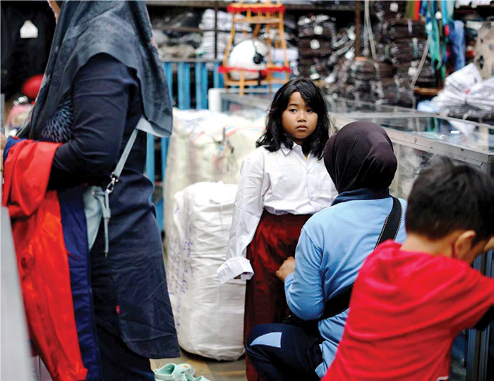 BELI BARU: Seorang pelajar SD mencoba seragam didampingi orang tuanya. BPS mencatat sektor pendidikan selalu memicu inflasi bulan Juli dan Agustus tiap tahunnya.