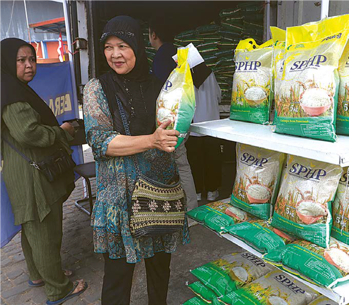 DIBANDEROL MURAH: Seorang ibu rumah tangga membeli beras SPHP kemasan 5 kg di gudang Bulog Cabang Malang kemarin.