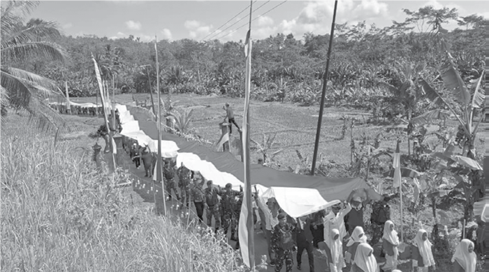 MERDEKA: Bendera Indonesia dengan ukuran panjang 80 meter dan lebar 3 meter diarak warga dan anggota TNI AD di Dusun Kedungbanteng Bawah, Desa Kedungbanteng, Kecamatan Sumbermanjing Wetan, kemarin.