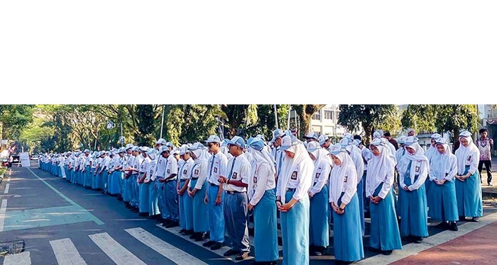 KETERBATASAN LAHAN: Ratusan siswa SMAN 8 Kota Malang mengikuti upacara HUT ke-80 Kemerdekaan RI di Jalan Veteran kemarin.