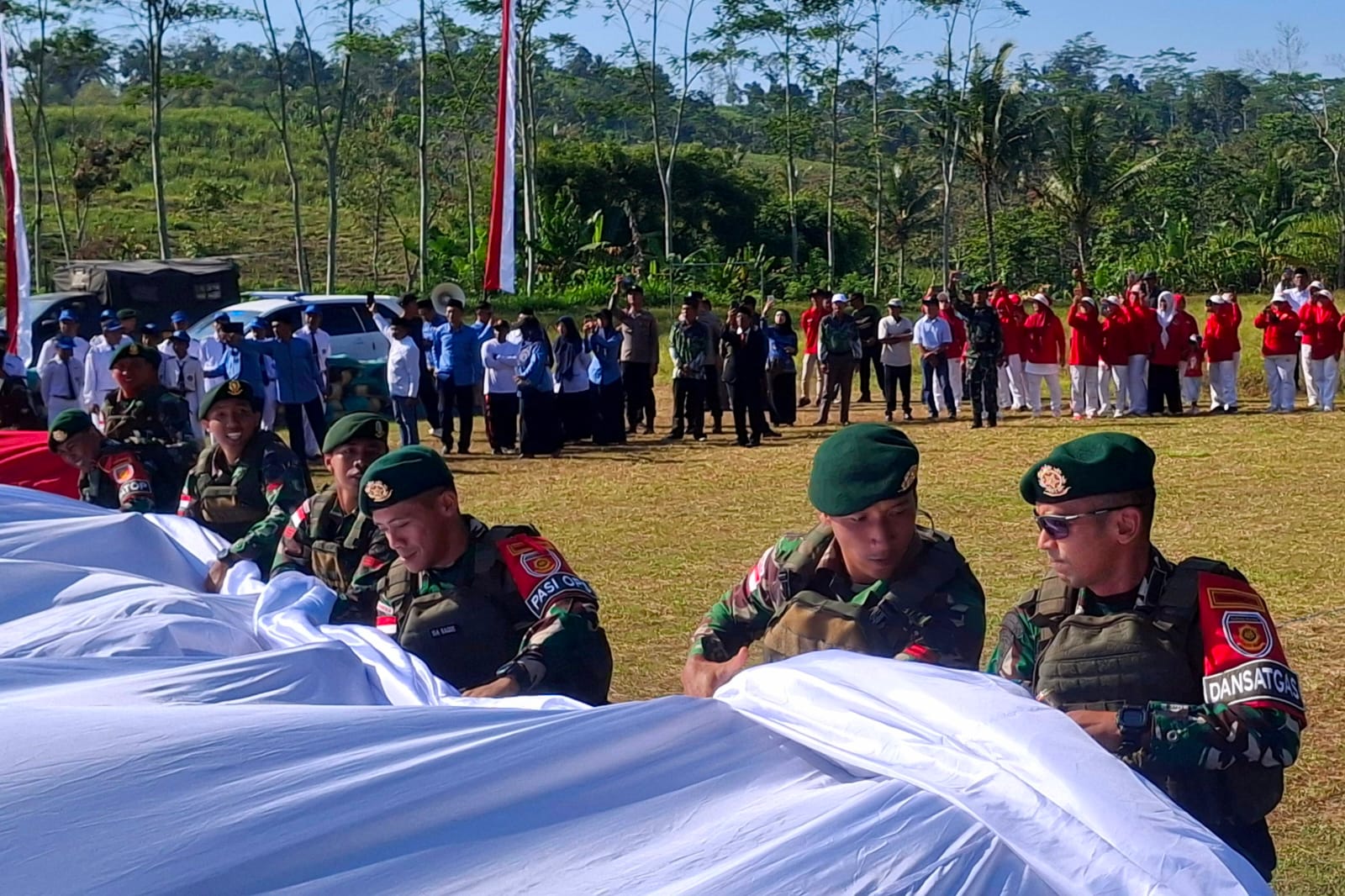 KERJA SAMA: Proses pembentangan bendera Merah Putih raksasa di tengah lapangan.