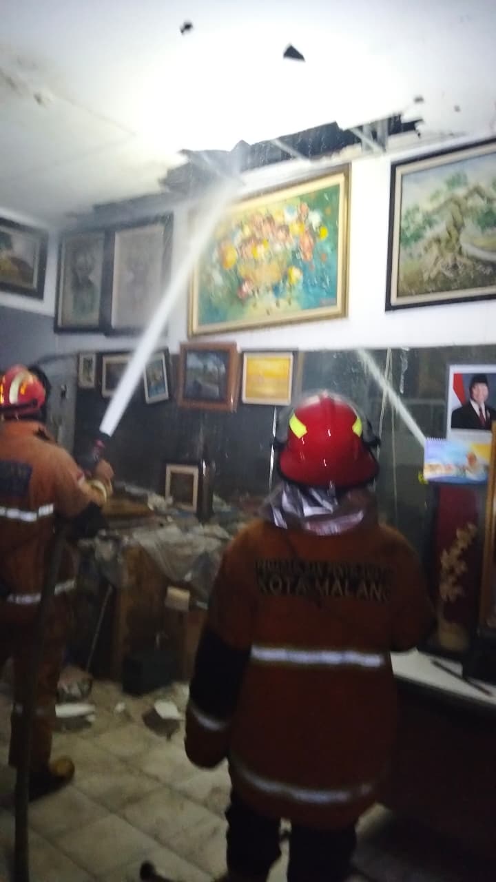 Petugas Pemadam Kebakaran Kota Malang berusaha memadamkan api yang menyambar Toko Jaya Abadi Pigura pada Senin (18/8) malam. (UPT Damkar Kota Malang for Radar Malang)
