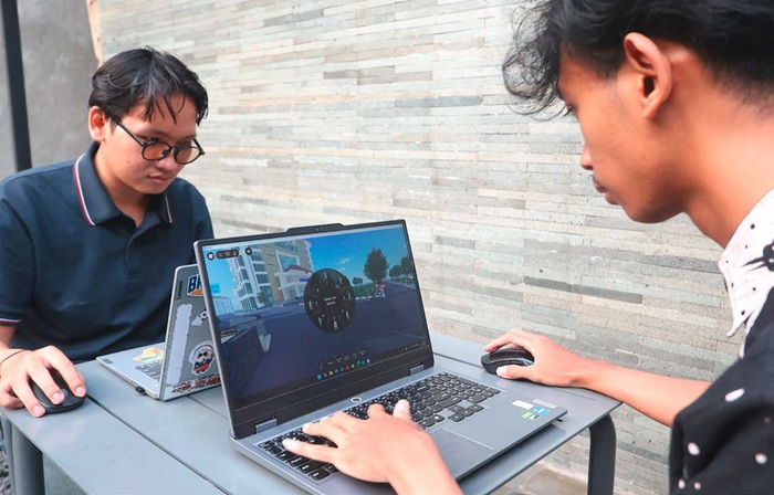 ADU KREATIVITAS: Dua anak muda sedang membuat peta di game Roblox melalui laptop. Lewat Roblox, mereka bisa menuangkan hobi dan silaturahmi antarpemain.