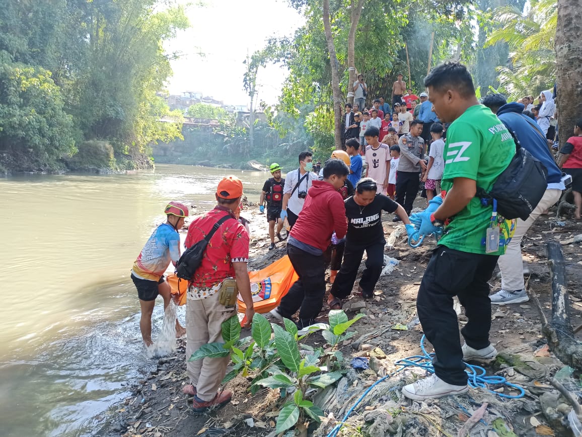 Personel Polsek Kedungkandang dan relawan mengevakuasi jenazah laki-laki tanpa identitas di Sungai Bango pada Senin (25/8). (Dokumen Polsek Kedungkandang untuk Radar Malang)