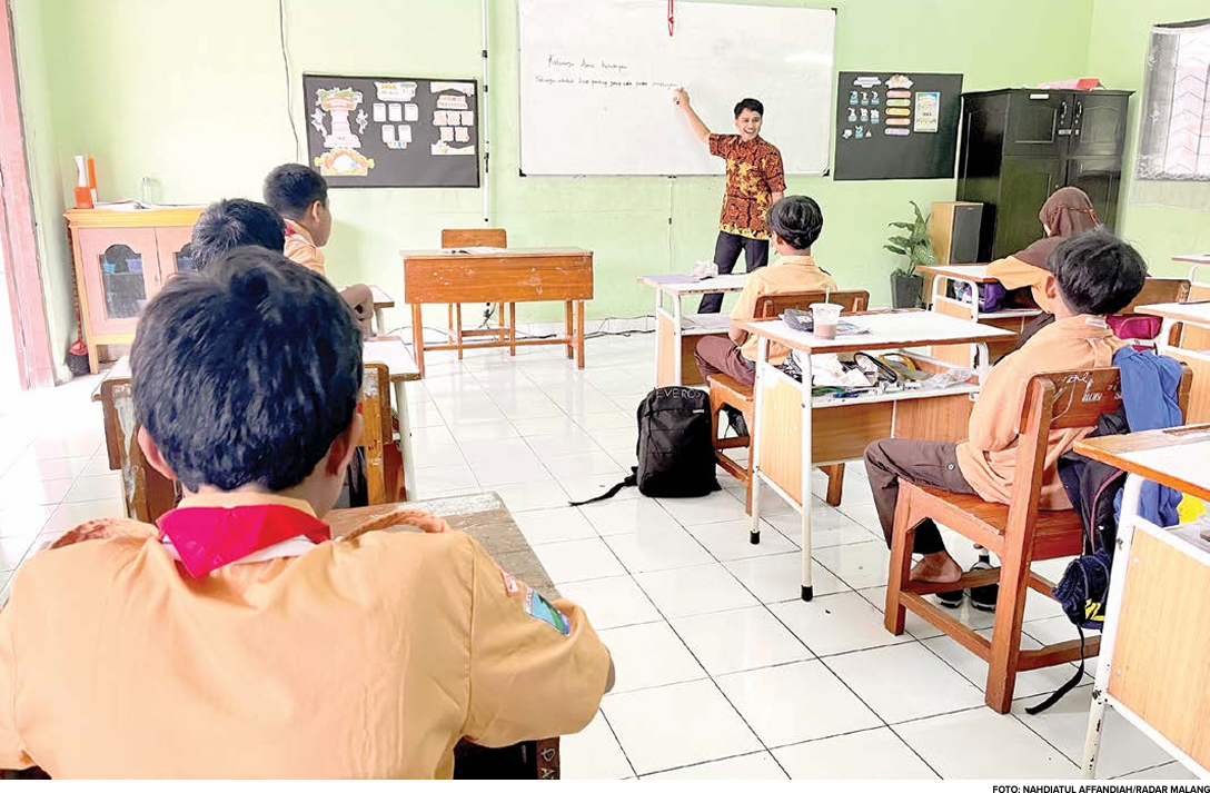 MENANTI KEPASTIAN: Seorang guru IPS SMP Sriwedari memberikan materi kepada murid di kelas kemarin pagi (29/8).