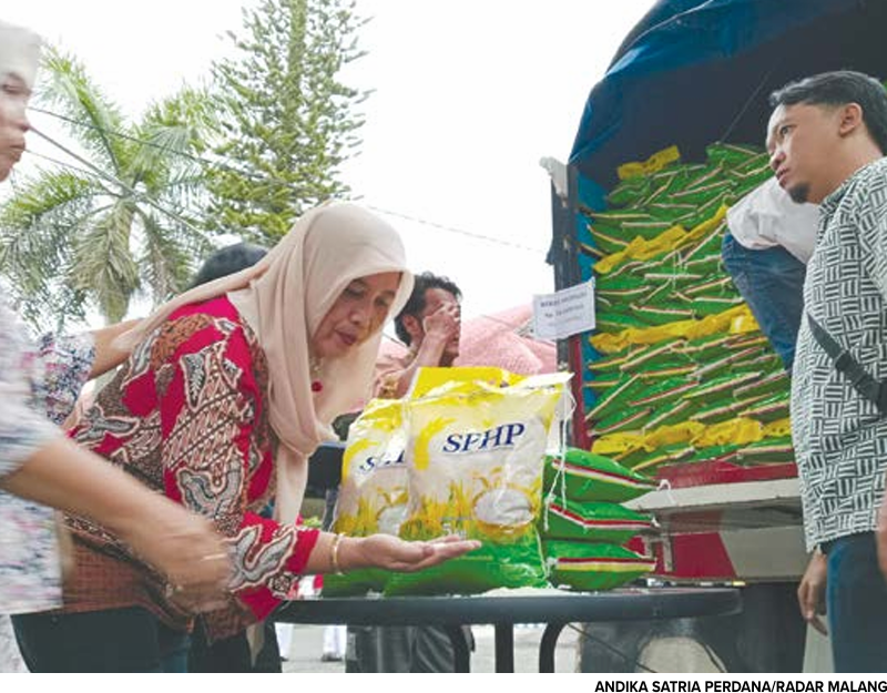 TEBUS MURAH: Warga membeli beras SPHP di gudang Bulog Cabang Malang pekan lalu.