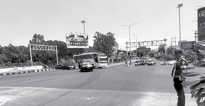 MELONJAK: Personel Polres Malang memantau arus lalu lintas menuju pintu masuk tol Singosari kemarin.