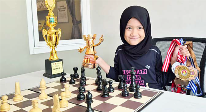 MEMBANGGAKAN: Bening Pambayun Lituhayu menggemgang piala dan medali yang diraih dalam turnamen catur regional sampai internasional kemarin (7/9).