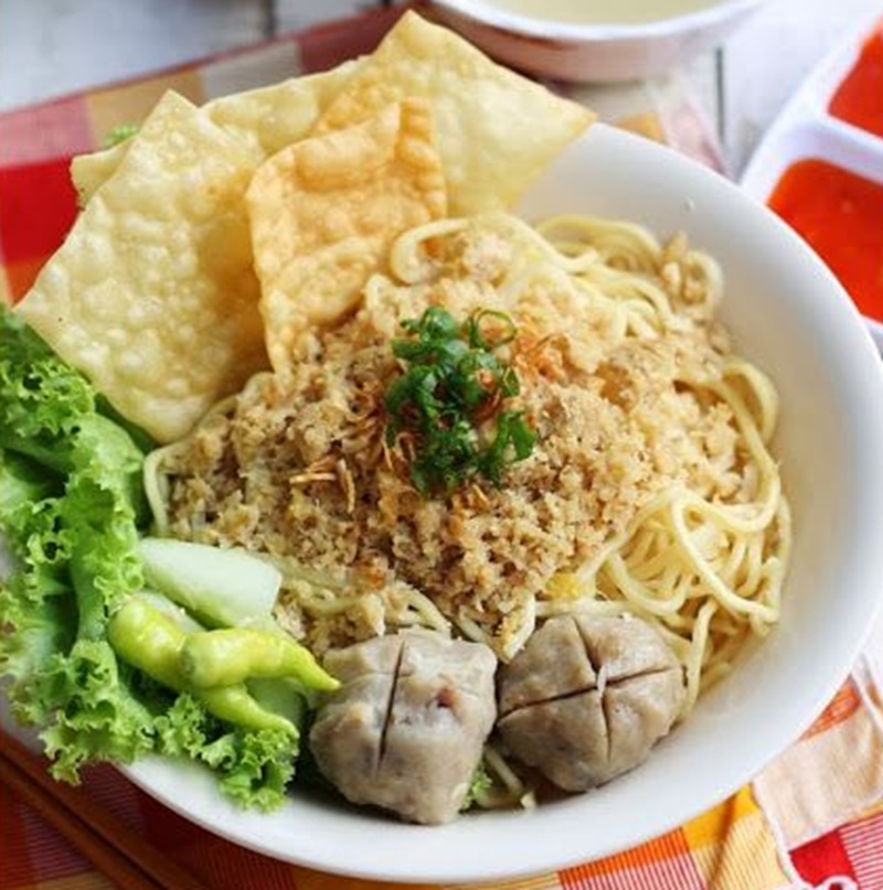 MENGGIURKAN: Pangsit mi ayam dengan topiing bakso, cabai, cincang ayam, selada