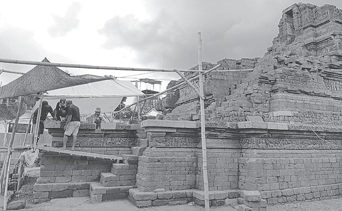PAKAI BATU ANDESIT: Pekerja melakukan penggantian batu Candi Jago yang sudah rusak.