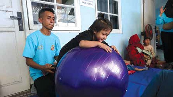 BINAAN AWAL: Seorang anak penyandang disabilitas melakukan terapi dengan bola di Posyandu Yayasan Bersama Anak Bangsa Malang (YBABM).