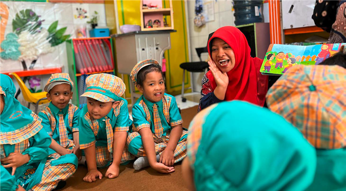 BERMAIN DAN BELAJAR: Guru TK Restu mendongeng dari buku ajar di depan murid-muridnya, kemarin. Tahun ini 64 guru TK dan SD berkesempatan melanjutkan kuliah lewat beasiswa sarjana Kemendikdasmen.
