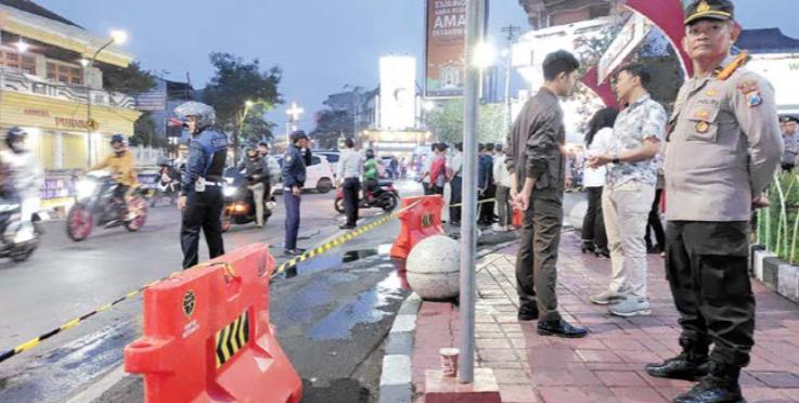 PENERTIBAN PKL LIAR: Satpol PP menggelar opsgab pemasangan road barrier dan police line di sepanjang lingkaran Alun-Alun Kota Wisata Batu pada Kamis malam lalu (18/9).