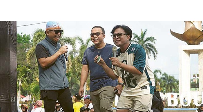 BERBAGI HADIAH: Kepala BPJS Ketenagakerjaan Kantor Cabang Malang Zulkarnain Mahading (kiri) memberi doorprize ke pengunjung CFD yang sudah mempunyai aplikasi JMO, kemarin.