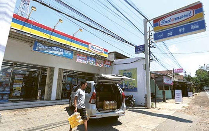 SUMBER PENDA PATAN: Konsumen memarkir kendaraan di halaman minimarket kemarin (23/9). Pengelola usaha wajib menyetor sebagian dari hasil parkir ke Pemkab Malang.