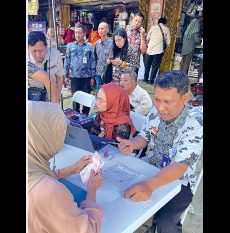 PELAYANAN: Petugas melayani warga yang hadir dalam program BMW di Pasar Dinoyo kemarin (25/9).