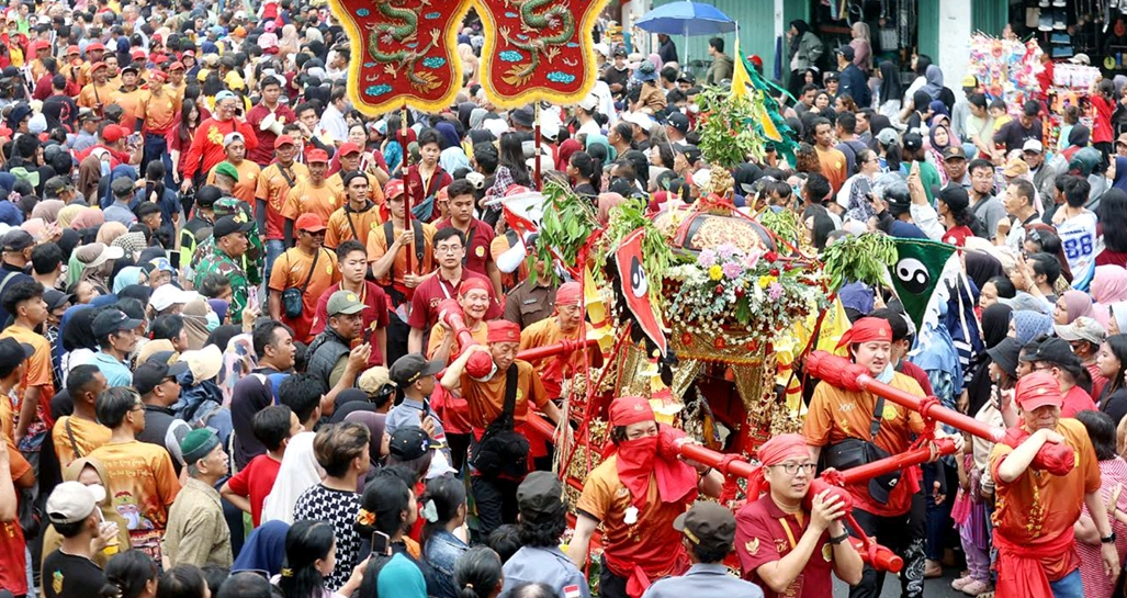 MERIAH: Warga cukup antusias menyaksikan kirab perayaan 200 tahun Kelenteng Eng An Kiong, kemarin siang (27/9). Foto kanan, Arca Kong Tek Cun Ong dari Kelenteng Yue Yang Tang Semarang ikut ambil bagia