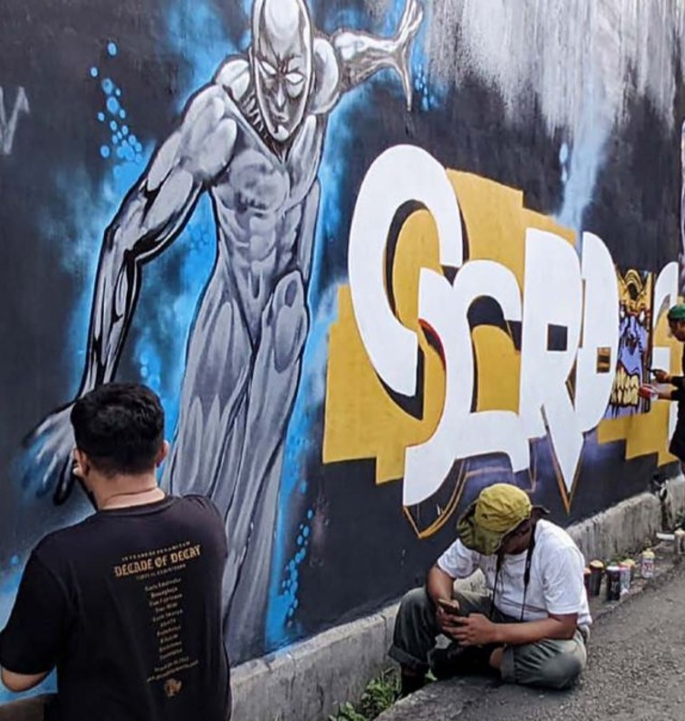 UNJUK KREATIVITAS: Seorang bomber di Kota Batu menggambar graffiti di dinding bangunan Jalan Diran, Keluran Sisir, Kecamatan Batu beberapa waktu lalu.