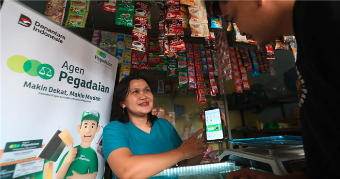SERBABISA : Seorang agen Pegadaian melayani konsumen yang hendak menjual emas dengan memakai aplikasi kemarin siang.